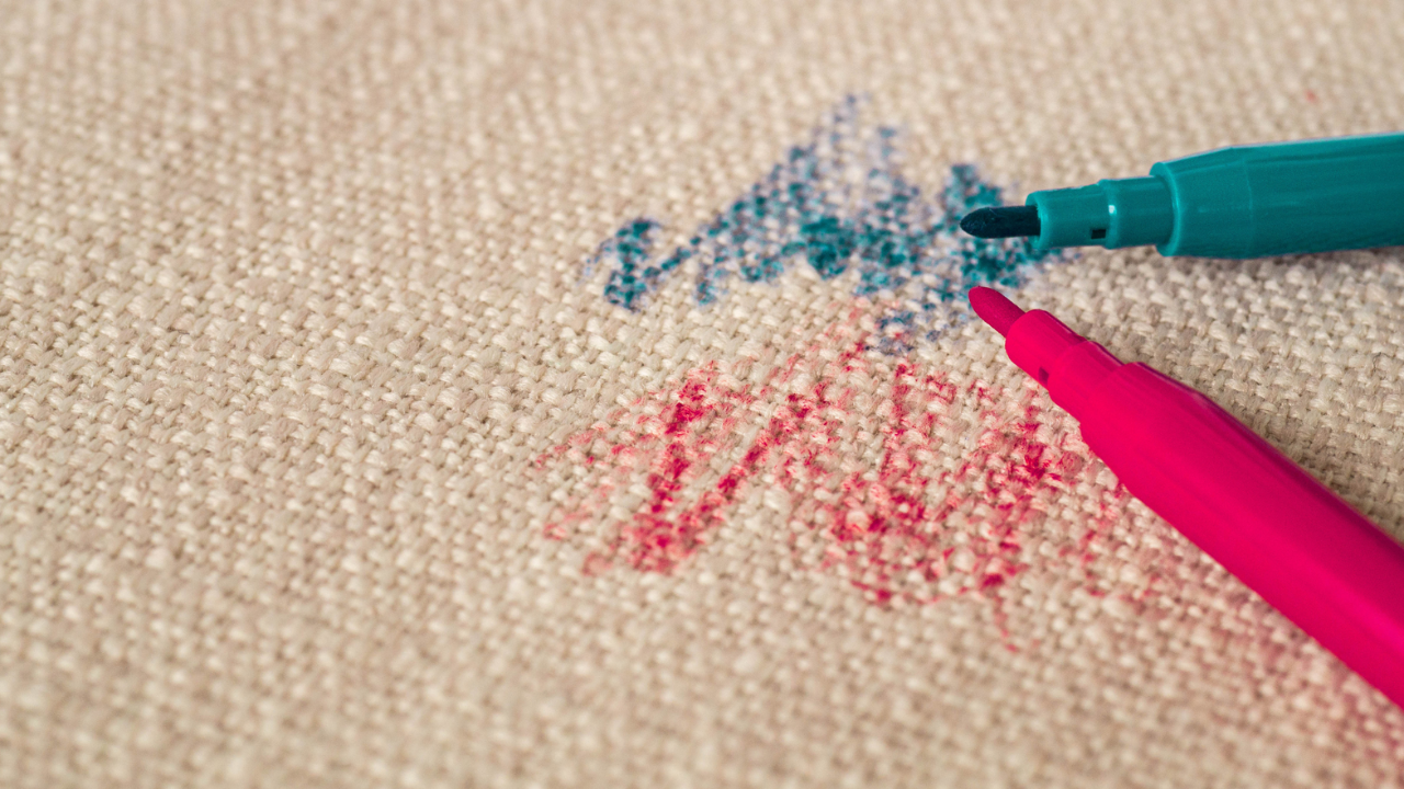 Image up close of a performance fabric being scribbled on and markers beside