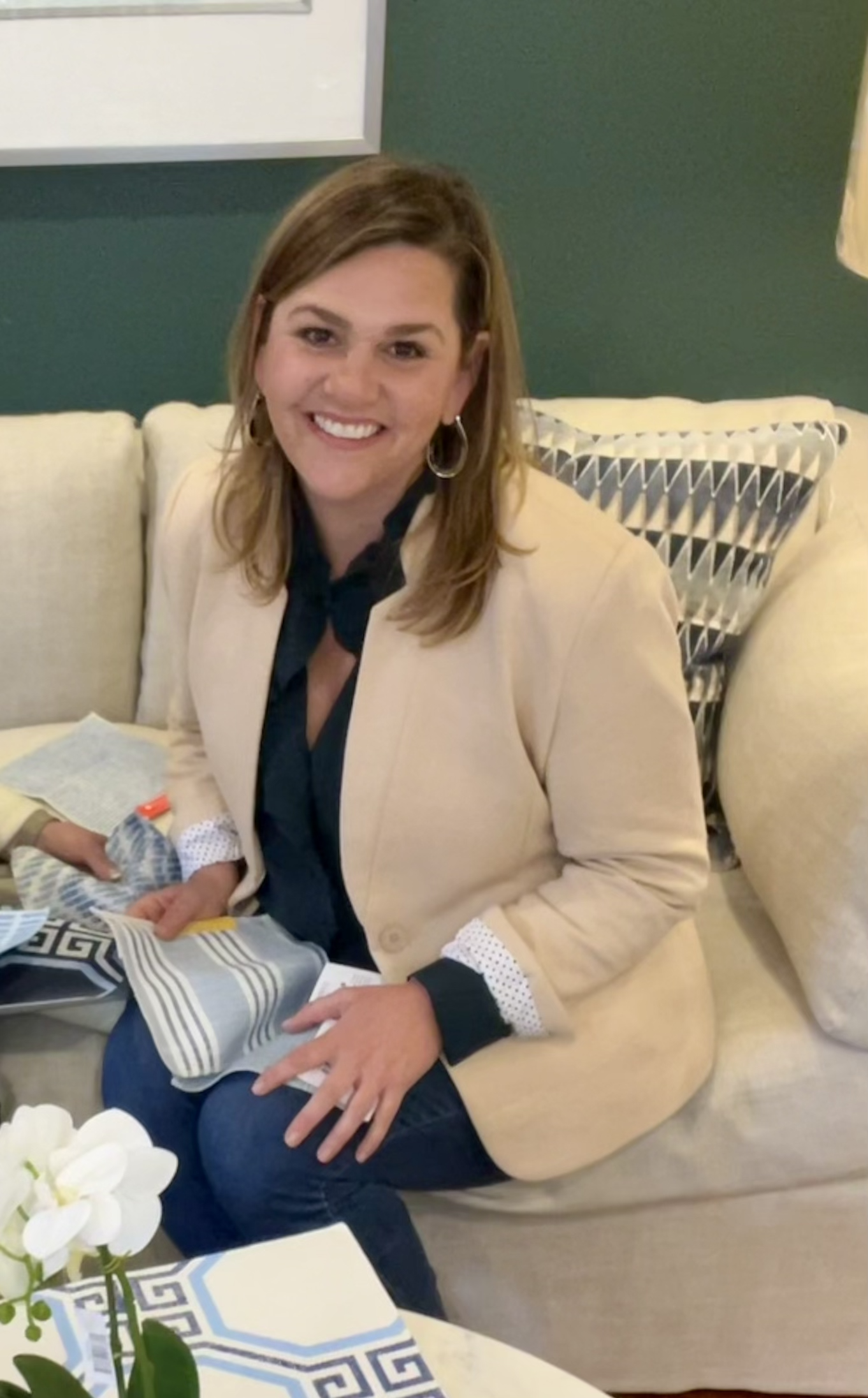 Portrait of Owner, Erin Zierfuss smiling at the camera sitting on a sofa with samples in her lap